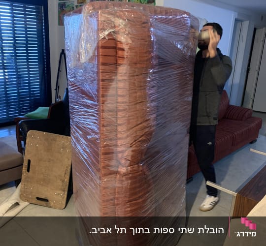 ספה עטופה בניילון נצמד לקראת מעבר דירה